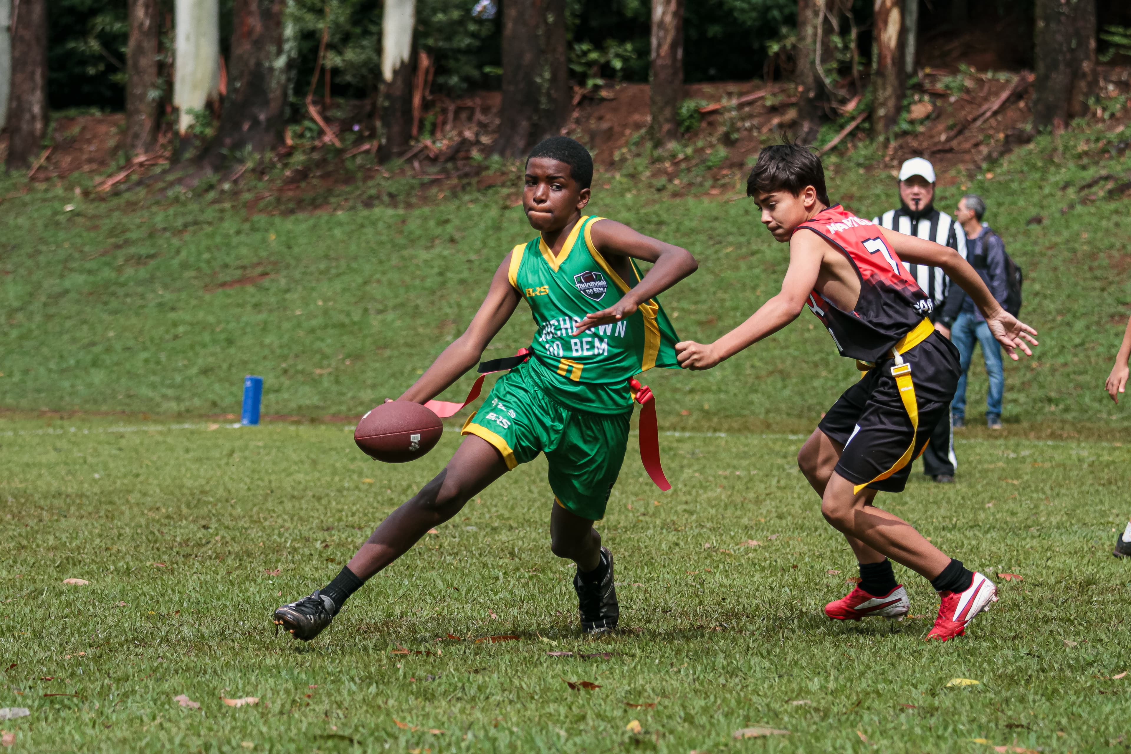 Criança do Touchdown do Bem em ação com a bola